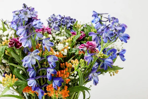 Bouquet of wild flowers on white wooden background. Graphic resources