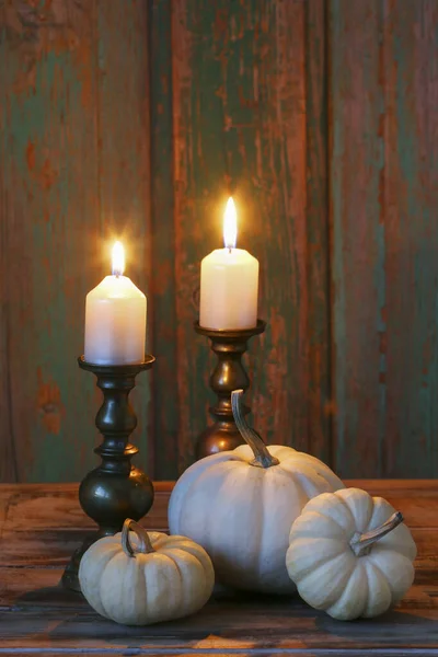 古董黄铜烛台上的白色南瓜和蜡烛 在后面是一堵木头墙 党的装饰 — 图库照片