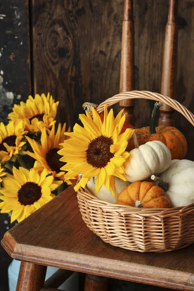 Eine Sonnenblume Und Ein Weidenkorb Mit Kürbissen Herbstdekor lizenzfreie Stockfotos