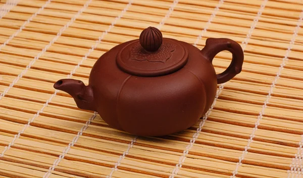 Brown teapot on the bamboo table-cloth — Stock Photo, Image
