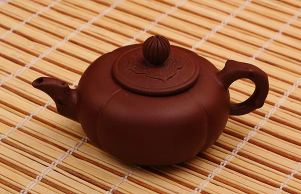 Brown teapot on the bamboo table-cloth — Stock Photo, Image