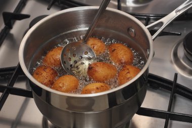 bir haşlanmış petrol ve delikli kaşık kızartma çörek