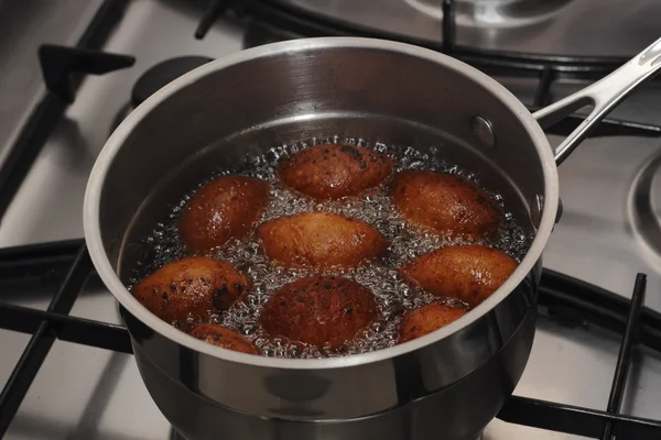 Doughnuts frying in a boiled oil in the pot — Stock Photo, Image