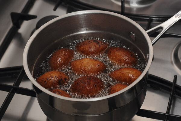 Doughnuts frying in a boiled oil in the pot