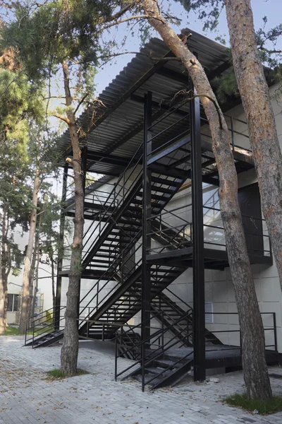 Escaliers d'urgence en métal noir sous un toit métallique — Photo