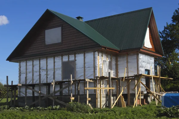 Wooden house covered by thermal foil — Stock Photo, Image