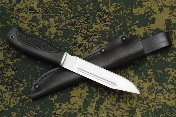 Στρατιωτικό μαχαίρι που βρίσκεται σε μαύρη δερμάτινη θήκη για καμουφλάζ φόντο — Φωτογραφία Αρχείου