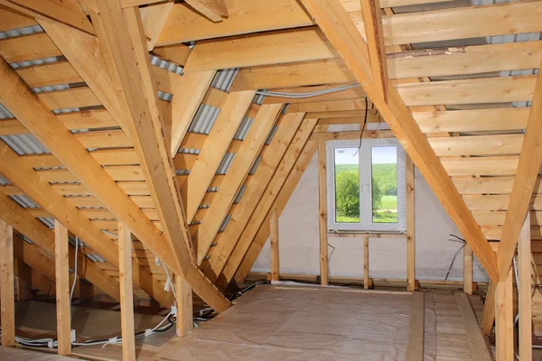 Attic under construction (wooden roof frame and plastic window inside photo) — Stock Photo, Image