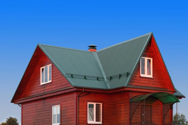 Maison en bois sous toit métallique vert avec fenêtres en plastique blanc — Photo