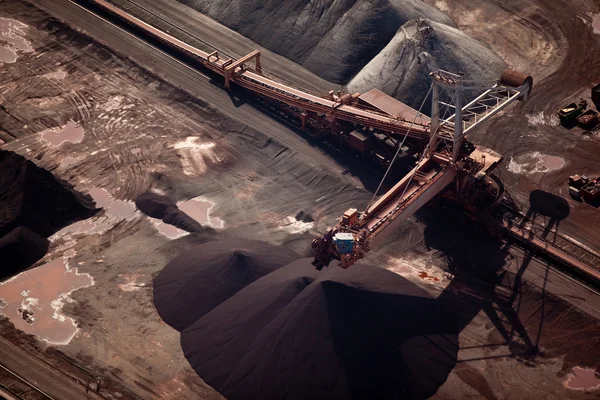Conveyor belt carrying coal and emptying onto a huge pile Stock Photo