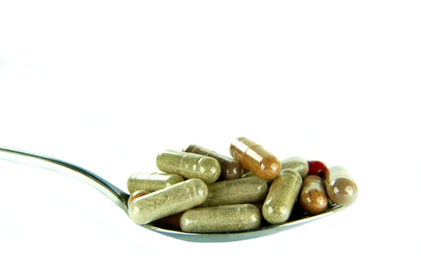 Closeup of herbal capsules on a spoon — Stock Photo, Image