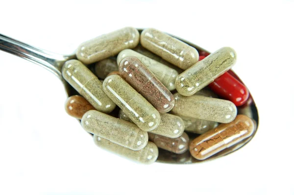 Closeup of herbal capsules on a spoon — Stock Photo, Image