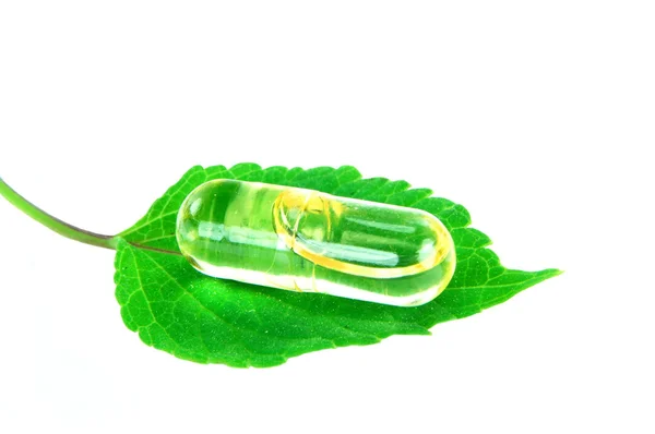 Fish oil capsule on melissa leaf — Stock Photo, Image