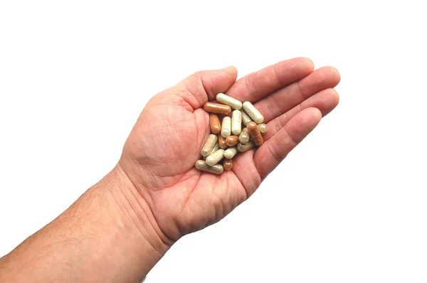 Herbal capsules on a hand — Stock Photo, Image