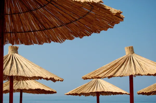 Sombrillas de paja en la hermosa playa montenegrina — Foto de Stock