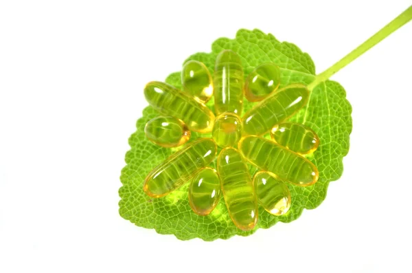 Fish oil capsules on sage leaf — Stock Photo, Image