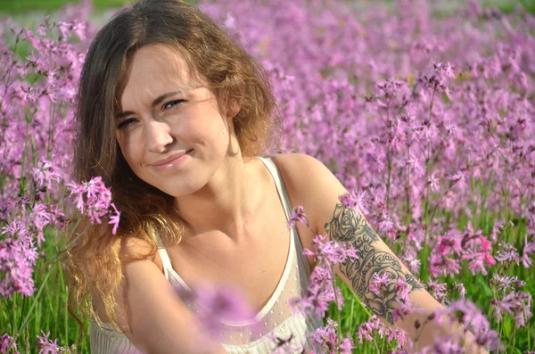 Menina bonita atraente no prado lindo cheio de flores selvagens — Fotografia de Stock