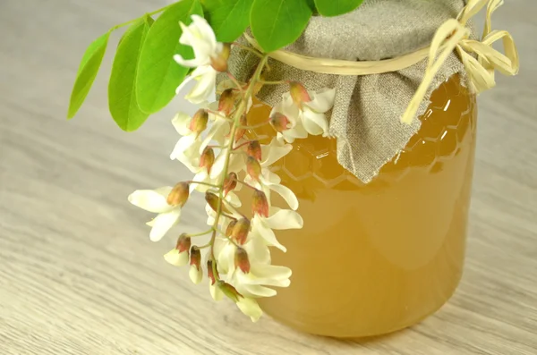 Vaso di miele fresco delizioso con fiori di acacia — Foto Stock