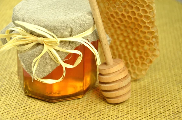 Jar of fresh delicious honey with honeycomb and honey dipper — Stock Photo, Image