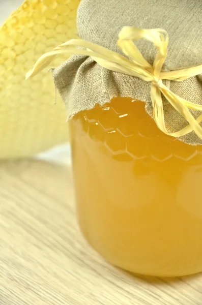 Jar of fresh delicious honey with honeycomb — Stock Photo, Image