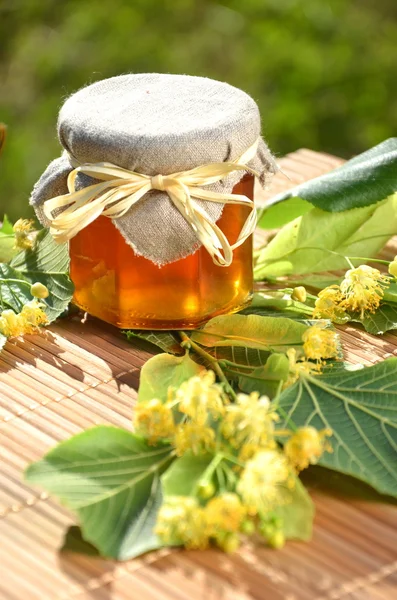 Pot de miel frais et délicieux avec des fleurs de tilleul — Photo