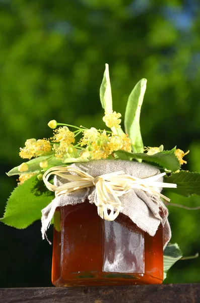 Jar of fresh and delicious honey with linden flowers — Stock Photo, Image