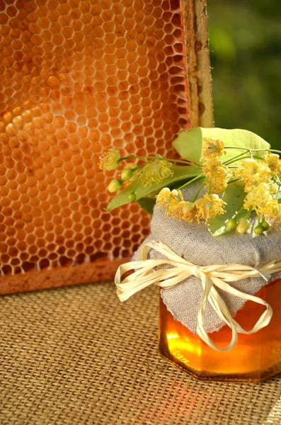 Jar of fresh and delicious honey with linden flowers and honeycomb — Stock Photo, Image