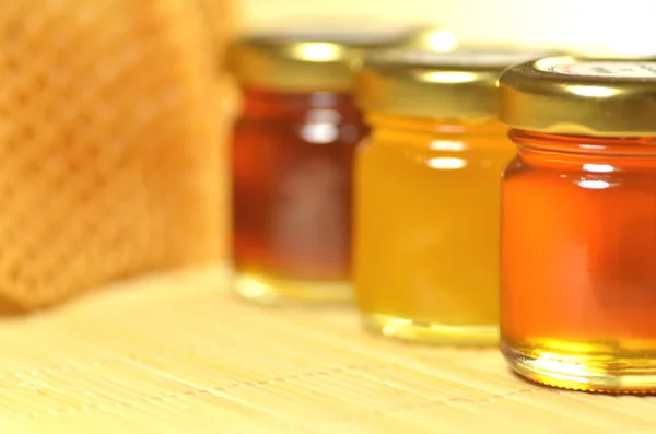 Variety of jars of fresh delicious honey with honeycomb — Stock Photo, Image