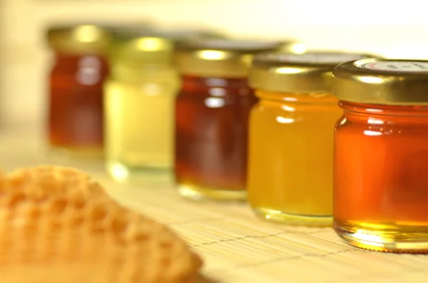 Variety of jars of fresh delicious honey with honeycomb — Stock Photo, Image