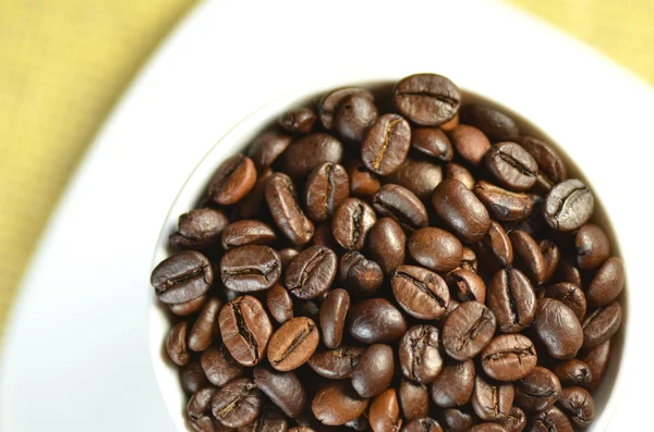 White coffee cup full of coffee beans — Stock Photo, Image