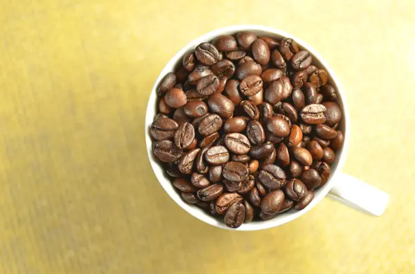 Vit kaffekopp full av kaffebönor — Stockfoto