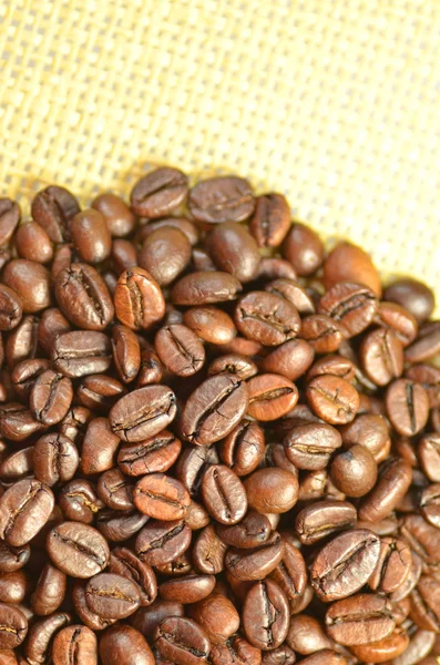 Roasted coffee beans on linen surface — Stock Photo, Image