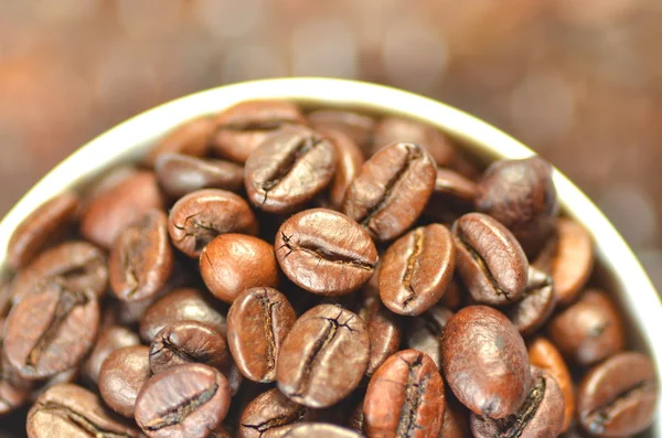 Copo de café branco cheio de grãos de café — Fotografia de Stock