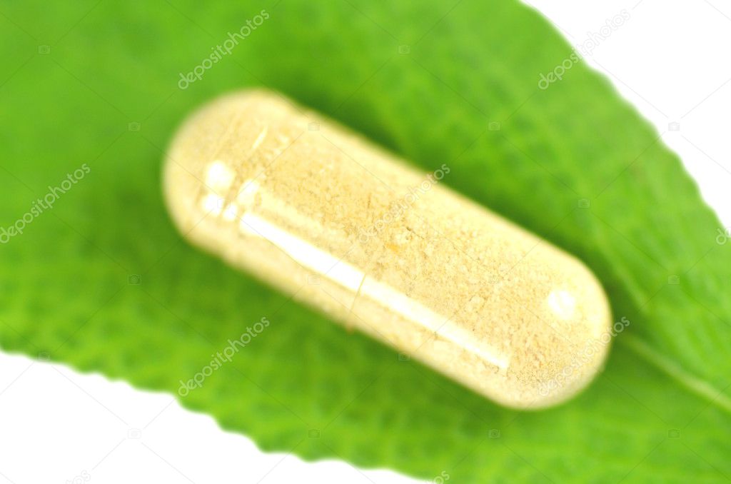 Closeup of royal jelly capsule on sage leaf isolated on white background