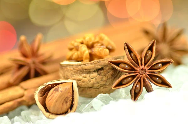 Saison de Noël, bâtonnets de cannelle, étoiles d'anis et noix sur fond bokeh — Photo