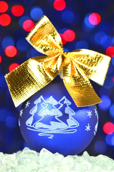 Christmas decoration, blue Christmas ball with golden bow in bokeh background — Stock Photo, Image