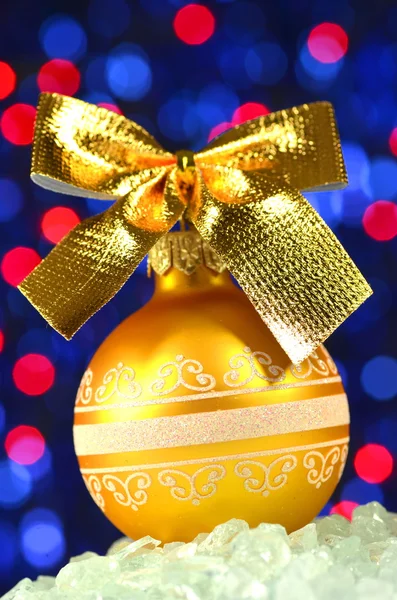 Christmas decoration, golden Christmas ball with golden bow in bokeh background — Stock Photo, Image