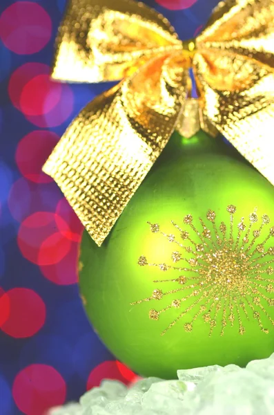 Decoración navideña, bola de Navidad verde con lazo dorado en fondo bokeh —  Fotos de Stock