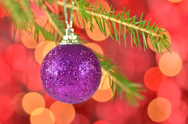 Christmas decoration, Christmas ball hanging on spruce twig against bokeh background — Stock Photo, Image