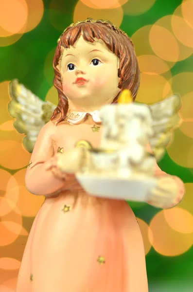 Kerstdecoratie, figuur van Engel houden een kaars tegen bokeh achtergrond — Stockfoto