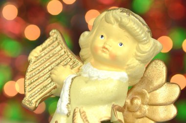 Noel süslemesi, melek figürü Bokeh arka planında arp çalıyor.