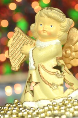 Noel süslemesi, melek figürü Bokeh arka planında arp çalıyor.