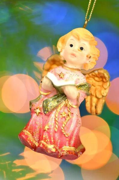 Christmas decoration, figure of little angel singing carols against bokeh background — Stock Photo, Image