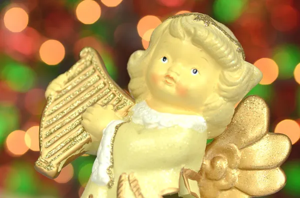 Christmas decoration, figure of angel playing the harp against bokeh background — Stock Photo, Image