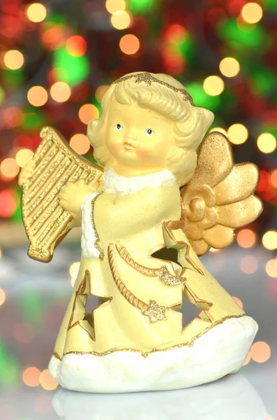 Christmas decoration, figure of angel playing the harp against bokeh background — Stock Photo, Image