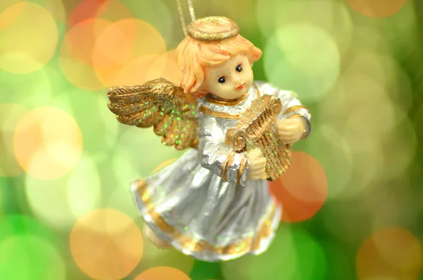 Kerstdecoratie, figuur van kleine engel spelen van de harp tegen bokeh achtergrond — Stockfoto