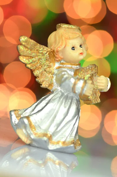 Decoração de Natal, figura de pequeno anjo tocando a harpa contra fundo bokeh — Fotografia de Stock