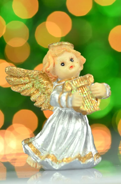 Decoração de Natal, figura de pequeno anjo tocando a harpa contra fundo bokeh — Fotografia de Stock