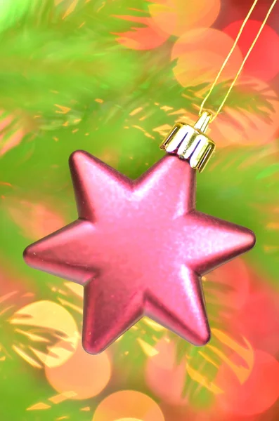 Decoração de Natal, rosa bola estrela de Natal pendurado no galho de abeto contra fundo bokeh — Fotografia de Stock