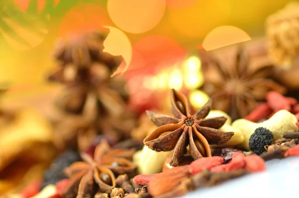 Christmas spices, nuts and dried fruits on bokeh background — Stock Photo, Image